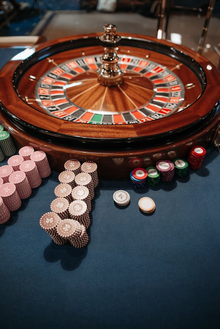 services-bg Roulette wheel on table with neatly stacked poker chips, capturing the essence of a casino.