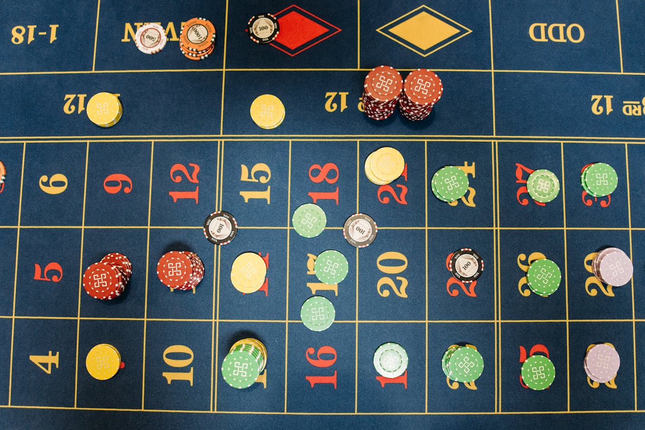about-us Aerial view of a roulette table with colorful poker chips showing a vibrant gambling scene.