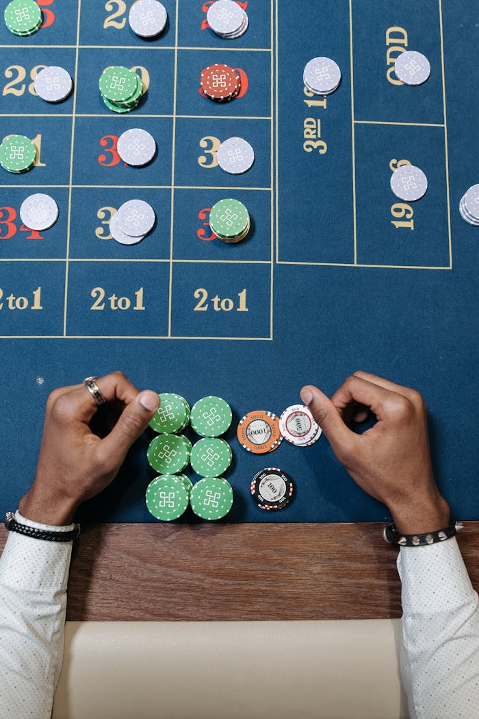 about-bg Hands arranging chips on a roulette table in a casino setting.